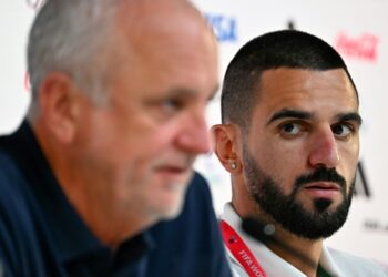 Australia's defender Aziz Behich (R) looks at coach Graham Arnold during a press conference. Photo: Chandan Khanna / AFP Source: AFP