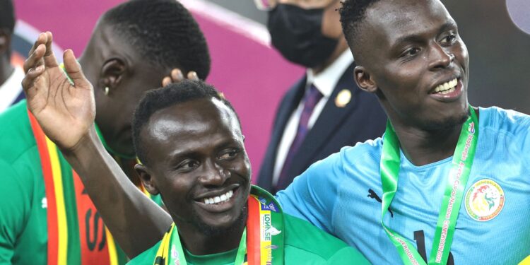 (From L) Senegal's forward Sadio Mane, Senegal's goalkeeper Edouard Mendy and Senegal's forward Bamba Dieng celebrate after winning the Africa Cup of Nations (CAN) 2021 final football match between Senegal and Egypt at Stade d'Olembe in Yaounde on February 6, 2022. (Photo by Kenzo TRIBOUILLARD / AFP) (Photo by KENZO TRIBOUILLARD/AFP via Getty Images)