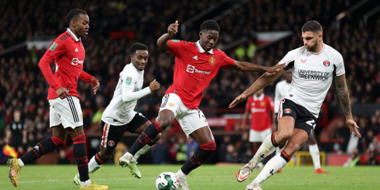 MANCHESTER, ENGLAND - JANUARY 10: Kobbie Mainoo of Manchester United controls the ball under pressure from Ryan Inniss of Charlton Athletic during the Carabao Cup Quarter Final match between Manchester United and Charlton Athletic at Old Trafford on January 10, 2023 in Manchester, England. (Photo by Naomi Baker/Getty Images)