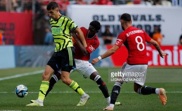 Kobbie Mainoo (C) and Bruno Fernades (8) of Manchester United fight for the ball with Kai Havertz (L) of Arsenal during the friendly football match between Manchester United and Arsenal at MetLife Stadium in East Rutherford, New Jersey, on July 22, 2023. (Photo by Leonardo Munoz / AFP) (Photo by LEONARDO MUNOZ/AFP via Getty Images)