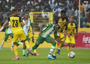Nigeria's Victor Osimhen, centre is challenged by Ghana’s Daniel Amartey, right, during their 2022 Qatar World Cup qualifying playoff second leg at Moshood Abiola Stadium in Abuja, Nigeria, Tuesday, March. 29, 2022. Ghana became the first team from Africa to qualify for the World Cup in Qatar after a 1-1 draw with Nigeria in the second leg of their playoff on Tuesday to advance on away goals. (AP Photo/Sunday Alamba)