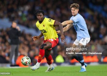 MANCHESTER, ENGLAND - SEPTEMBER 24: Kwadwo Baah of Watford battles for possession with John Stones of Manchester City during the Carabao Cup Third Round match between Manchester City and Watford  at Etihad Stadium on September 24, 2024 in Manchester, England. (Photo by James Gill - Danehouse/Getty Images)