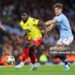 MANCHESTER, ENGLAND - SEPTEMBER 24: Kwadwo Baah of Watford battles for possession with John Stones of Manchester City during the Carabao Cup Third Round match between Manchester City and Watford  at Etihad Stadium on September 24, 2024 in Manchester, England. (Photo by James Gill - Danehouse/Getty Images)