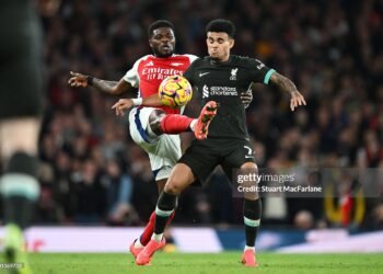 LONDON, ENGLAND - OCTOBER 27: Luis Diaz of Liverpool is challenged by Thomas Partey of Arsenal during the Premier League match between Arsenal FC and Liverpool FC at Emirates Stadium on October 27, 2024 in London, England. (Photo by Stuart MacFarlane/Arsenal FC via Getty Images)