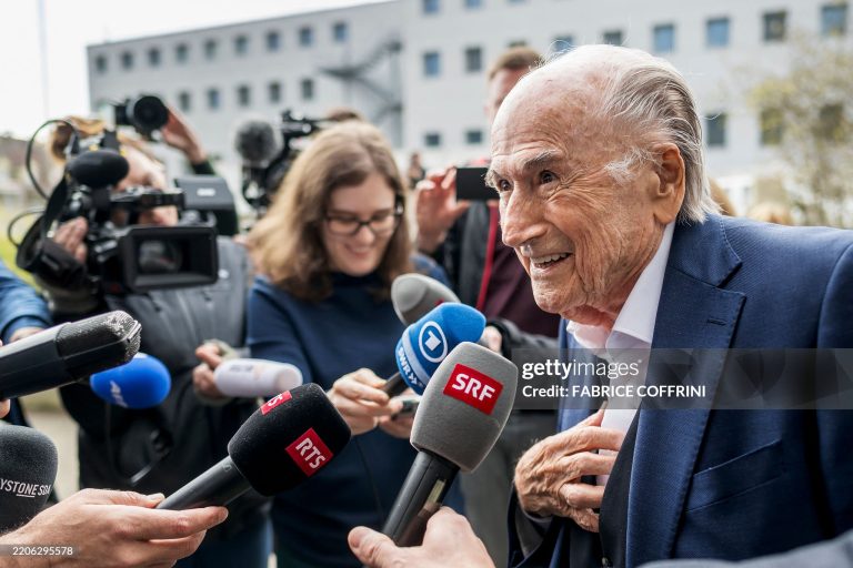 TOPSHOT - Former FIFA president Sepp Blatter (R) addresses media as he leaves the courthouse after the verdict of an appeal by Swiss Attorney General's office against former UEFA and FIFA presidents over a suspected fraudulent payment, in Muttenz near Basel, on March 25, 2025. Former FIFA president Sepp Blatter and ex-UEFA chief Michel Platini were acquitted again  on March 25, 2025 on appeal by a Swiss court in a long-running corruption case. (Photo by Fabrice COFFRINI / AFP) (Photo by FABRICE COFFRINI/AFP via Getty Images)