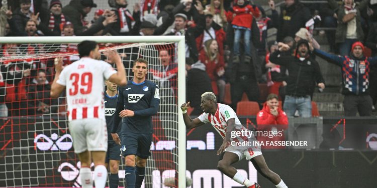 FC Cologne's German forward #09 Ragnar Ache (R) celebrates his 1-0 during the German first division Bundesliga football match 1 FC Cologne v TSG 1899 Hoffenheim in Cologne, western Germany, on February 21, 2026. (Photo by INA FASSBENDER / AFP via Getty Images) / DFL REGULATIONS PROHIBIT ANY USE OF PHOTOGRAPHS AS IMAGE SEQUENCES AND/OR QUASI-VIDEO