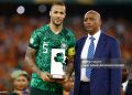 TOPSHOT - Nigeria's defender #5 William Troost-Ekong holds the Golden Ball award while standing next to President of the Confederation of African Football (CAF) Patrice Motsepe (R) during prize giving ceremony following the Africa Cup of Nations (CAN) 2024 final football match between Ivory Coast and Nigeria at Alassane Ouattara Olympic Stadium in Ebimpe, Abidjan on February 11, 2024. (Photo by Daniel BELOUMOU OLOMO / AFP) (Photo by DANIEL BELOUMOU OLOMO/AFP via Getty Images)