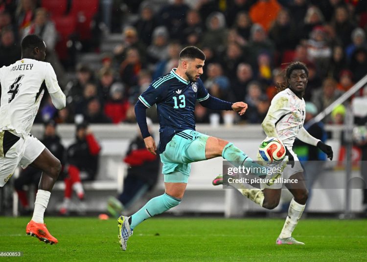 30 March 2026, Baden-Württemberg, Stuttgart: Soccer, Men, International match, Germany - Ghana, MHP Arena. Deniz Undav (M, Germany) gets the ball against Caleb Yirenkyi (r, Ghana) and Jonas Adjetey (Ghana). Photo: Tom Weller/dpa - IMPORTANT NOTE: In accordance with the regulations of the DFL German Football League and the DFB German Football Association, it is prohibited to utilize or have utilized photographs taken in the stadium and/or of the match in the form of sequential images and/or video-like photo series. (Photo by Tom Weller/picture alliance via Getty Images)