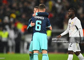 30 March 2026, Baden-Württemberg, Stuttgart: Soccer, men, international matches, Germany - Ghana, MHP Arena. Lennart Karl (back, Germany) is happy after the game with Joshua Kimmich (Germany), Kamaldeen Sulemana (Ghana) runs past the two. Photo: Tom Weller/dpa - IMPORTANT NOTE: In accordance with the regulations of the DFL German Football League and the DFB German Football Association, it is prohibited to utilize or have utilized photographs taken in the stadium and/or of the match in the form of sequential images and/or video-like photo series. (Photo by Tom Weller/picture alliance via Getty Images)