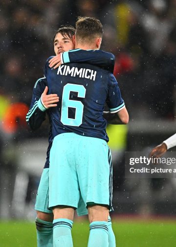 30 March 2026, Baden-Württemberg, Stuttgart: Soccer, men, international matches, Germany - Ghana, MHP Arena. Lennart Karl (back, Germany) is happy after the game with Joshua Kimmich (Germany), Kamaldeen Sulemana (Ghana) runs past the two. Photo: Tom Weller/dpa - IMPORTANT NOTE: In accordance with the regulations of the DFL German Football League and the DFB German Football Association, it is prohibited to utilize or have utilized photographs taken in the stadium and/or of the match in the form of sequential images and/or video-like photo series. (Photo by Tom Weller/picture alliance via Getty Images)