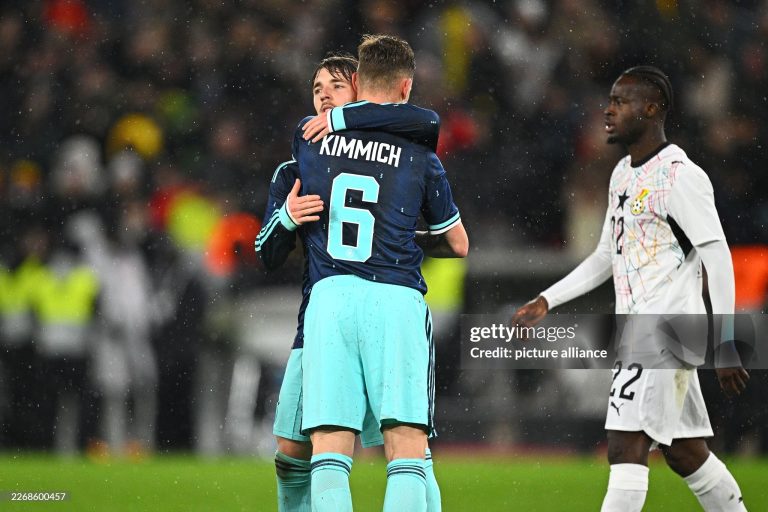 30 March 2026, Baden-Württemberg, Stuttgart: Soccer, men, international matches, Germany - Ghana, MHP Arena. Lennart Karl (back, Germany) is happy after the game with Joshua Kimmich (Germany), Kamaldeen Sulemana (Ghana) runs past the two. Photo: Tom Weller/dpa - IMPORTANT NOTE: In accordance with the regulations of the DFL German Football League and the DFB German Football Association, it is prohibited to utilize or have utilized photographs taken in the stadium and/or of the match in the form of sequential images and/or video-like photo series. (Photo by Tom Weller/picture alliance via Getty Images)