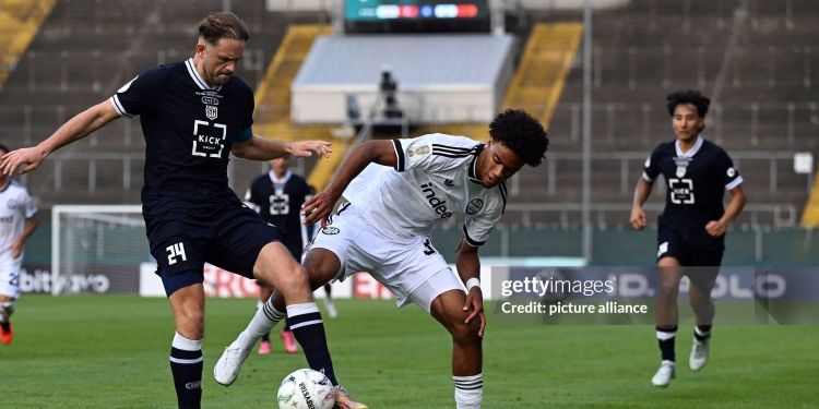 21 August 2026, North Rhine-Westphalia, Krefeld: Soccer, Men: DFB Cup, SC St. Tönis 11/20 vs. Eintracht Frankfurt, First Round, Grotenburg Stadium; Bilal Brusdeilins (left, Tönis) and Malik Pimpong (Eintracht Frankfurt) battle for the ball. Photo: Federico Gambarini/dpa - IMPORTANT NOTICE: In accordance with the regulations of the Bundesliga and the DFB (German Football Association), it is prohibited to use or allow the use of photographs taken in the stadium and/or during the game in the form of sequential images and/or video-like photo series. (Photo by Federico Gambarini/picture alliance via Getty Images)