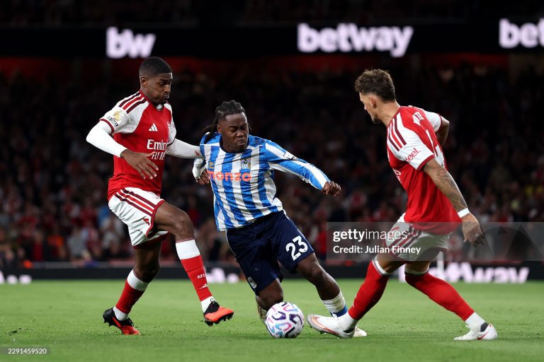 LONDON, ENGLAND - AUGUST 21: Brandon Thomas-Asante of Coventry City is challenged by Cristhian Mosquera and Ben White of Arsenal during the Premier League 2026/27 match between Arsenal FC and Coventry City at Emirates Stadium on August 21, 2026 in London, England. (Photo by Julian Finney/Getty Images)